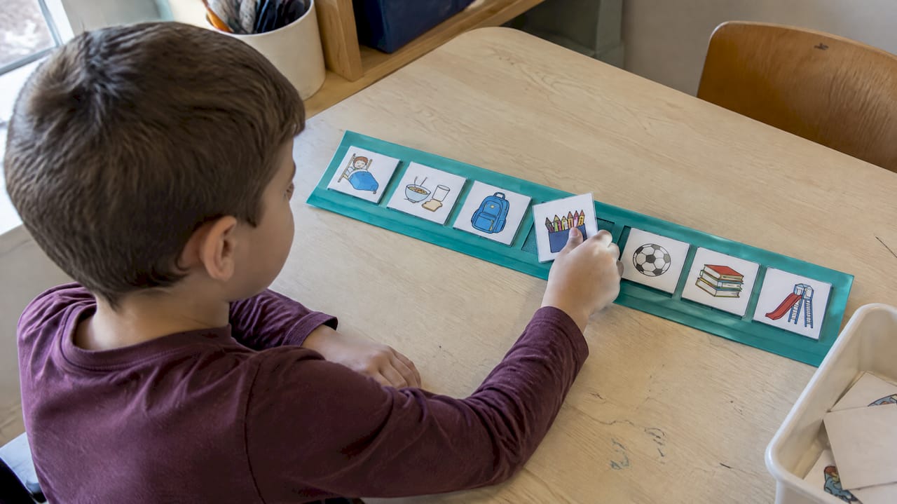 Un bambino sfoglia un'agenda visiva con pittogrammi