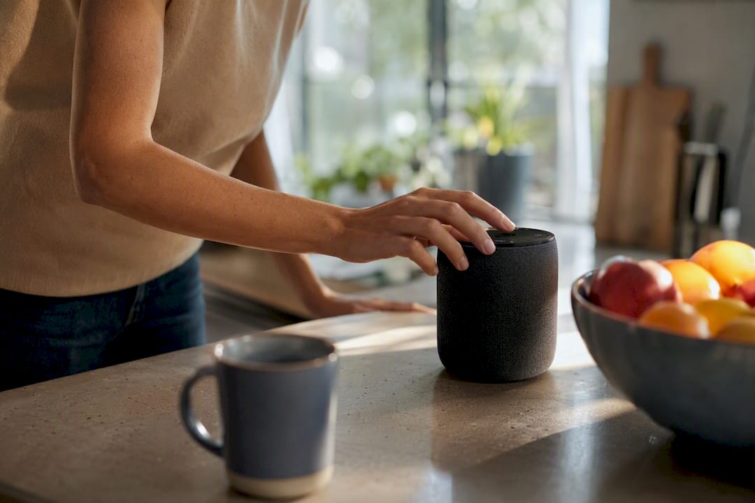 Hands selecting music playlist on speaker
