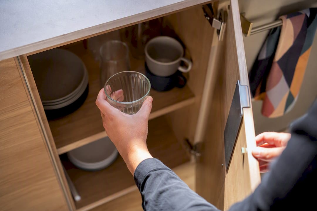 Hands loading single cup into dishwasher