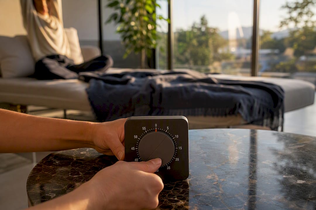 Hands winding timer and person stretching before task