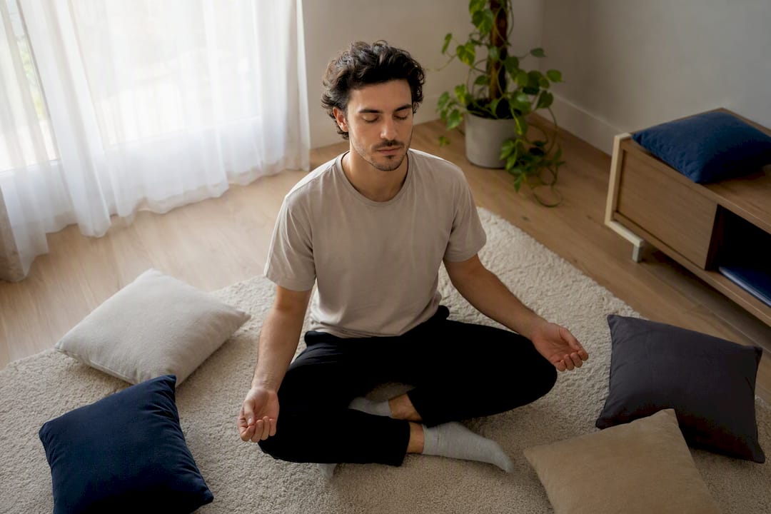 Jeune adulte pratiquant la respiration en pleine conscience à l'intérieur