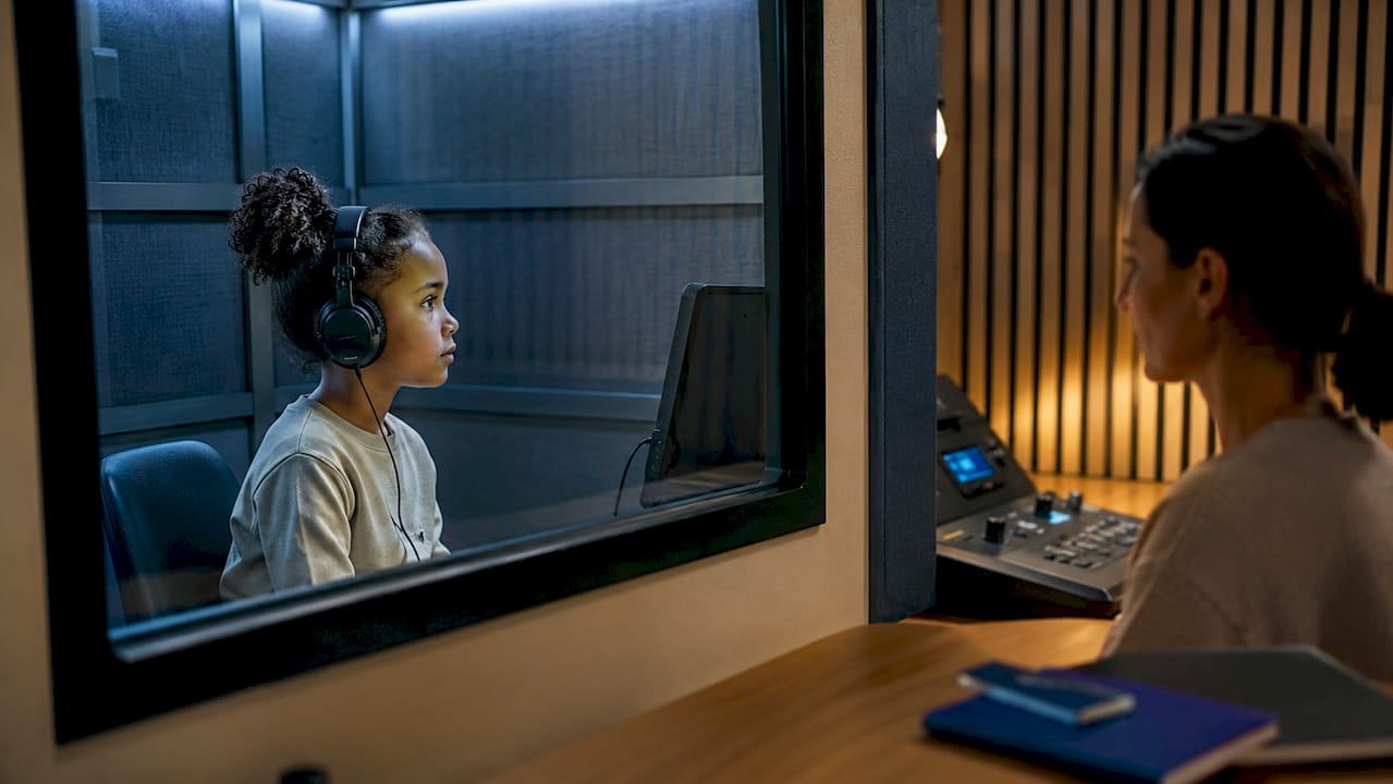 Enfant en train de passer un test auditif en cabine