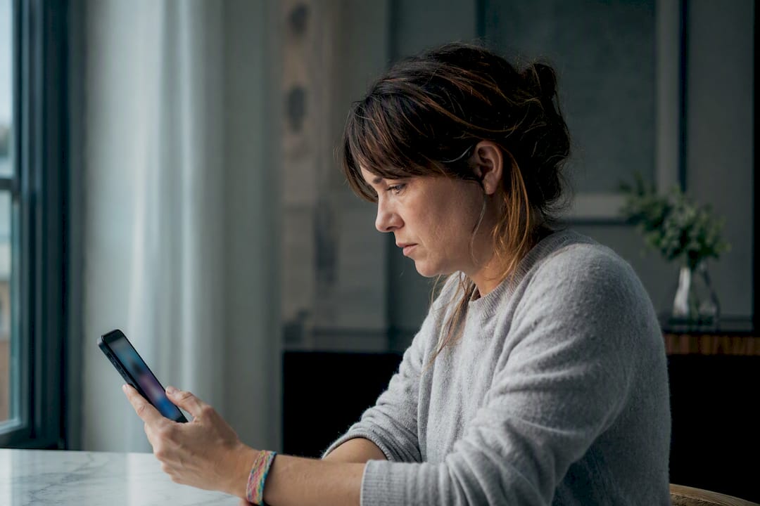 Una donna adulta rilegge un messaggio senza risposta